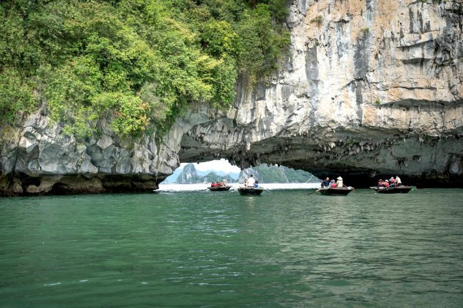 People Sailing in Boats Under a Rock Formation in Ha Long Bay, Vietnam