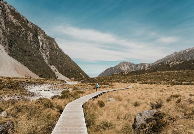 Photo of a Man Walking on Boardwalk