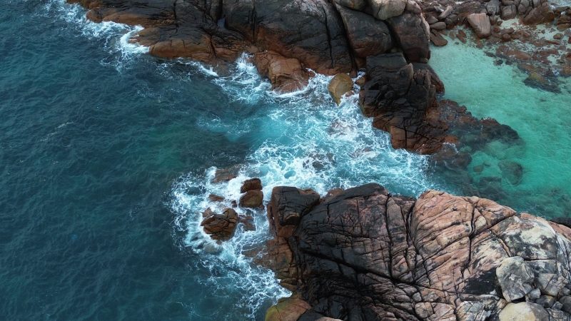 a bird's eye view of the ocean and rocks